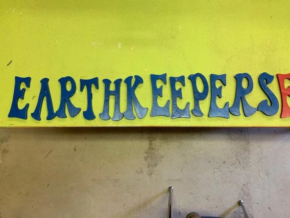 “EARTHKEEPERS” in blue wooden letters