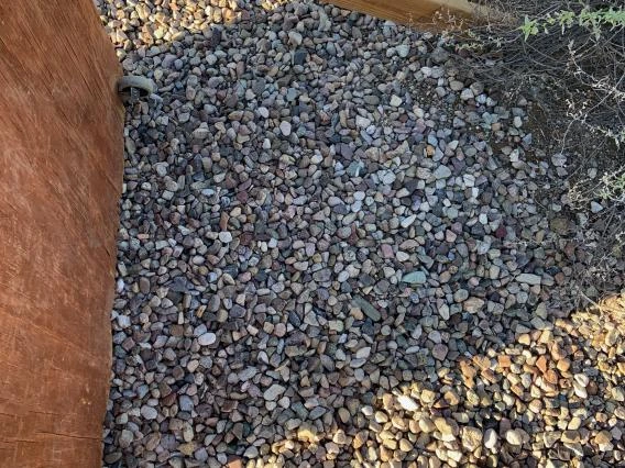 A view of the lower back of a shelving unit on gravel